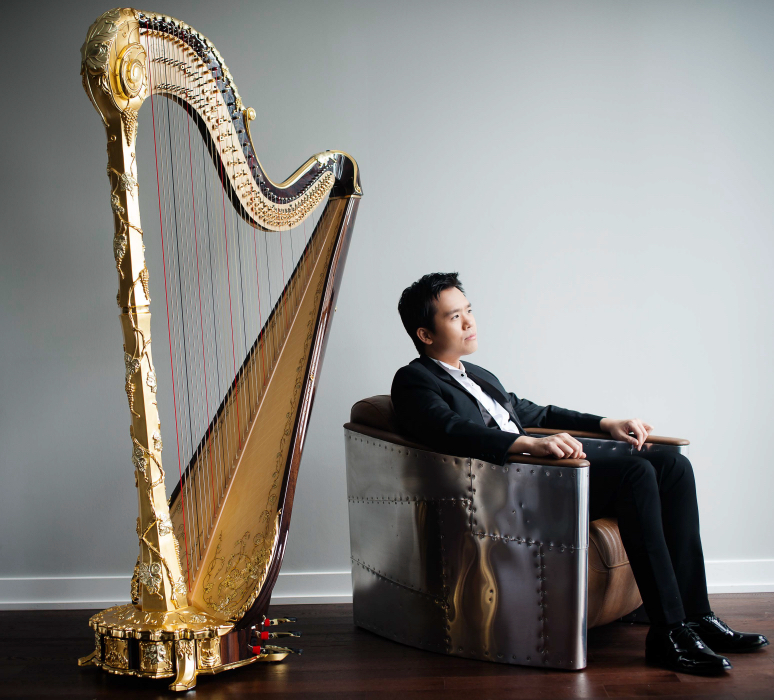 Andrew sitting beside a gold harp