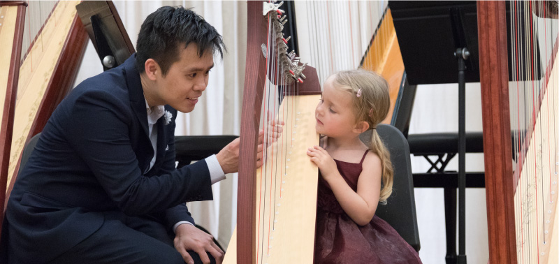 Harp teacher guiding young student